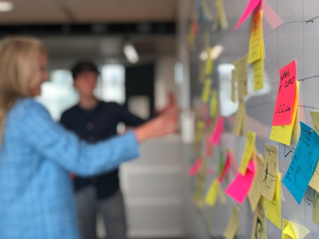 A facilitator leading a group workshop with sticky notes on a wall